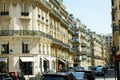 Street in Paris with cars, people, window shops