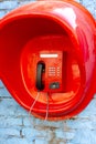 Street payphone telephone set in a red booth Royalty Free Stock Photo