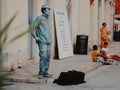 Street performer mime stands in the form of live silver statue sculpture in the center of the old city. Live perfomance for