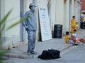 Street performer mime stands in the form of live silver statue sculpture in the center of the old city. Live perfomance for