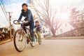 Street photo of boy in tandem bike towed by father