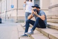 Street photographer sits on a step.