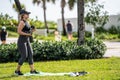 Street photography healthy woman working out in the park lifting weights