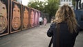 Street photography, photosession of a young loving couple. Action. Rear view of a photographer taking pictures of a girl