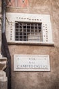 Street plaque Via Del Campidoglio at the foot of the statue of Romulus and Remus in Rome