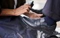 Street, polish or hands of man with shoes in cleaning service in city for shining with wax, trade and job. Closeup Royalty Free Stock Photo