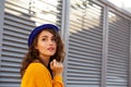 Street portrait of awesome model wearing blue hat posing with su