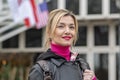 Street portrait of a blonde 40-45 years old on a blurry background of American and Austrian flags, European city, Royalty Free Stock Photo