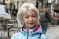 Street portrait of an elderly woman blonde 60-70 years old on the blurred background of the street, Royalty Free Stock Photo