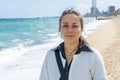 Street portrait of a happy woman 40-45 years old on the background of the sea and beach.