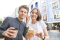 Street portrait of a happy young couple who listens to music from one headphone. girl smiles