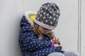 Street portrait of a little girl looking at a wrist electronic children`s watch