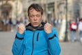 Street portrait of a 45-50-year-old man with an angry expression, wants to fight, on a city background, medium plan.