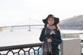 Street portrait of young brunette model wearing coat and hat. Em