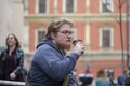 Street portrait of a young man with glasses and a beard 25-30 years old with blond hair drinking coffee from a paper cup against Royalty Free Stock Photo