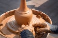 Street potter makes a vase of clay on a potter`s wheel.