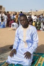 Street prayer, a Friday in Senegal. Unidentified young Muslim man praying in the street, celebration clothing