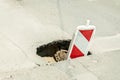 Street reconstruction or construction barricade traffic danger caution sign cover the open hole of damaged and cracked asphalt on Royalty Free Stock Photo