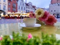 Street restaurant cup  of coffee and flowers  table top in Tallinn old town medieval city stree town hall square Royalty Free Stock Photo