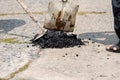 Street resurfacing. Fresh asphalt construction. Bad road. Construction site is worker laying repair asphalt road. Covering the pit