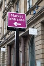 Street road sign giving directions to Market entrance. Information for tourists and shoppers