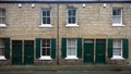 Street with a row of typical british old terraced houses with green doors and window shutters in durham england Royalty Free Stock Photo