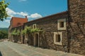 Street with rustic houses and stone walls with plants