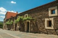 Street with rustic houses and stone walls with plants