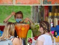 A street saleswoman pours a fruit cocktail with ice during a record hot day.