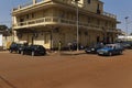 Street scene in the city of Bissau with people passing in front of an old hotel, in Guinea-Bissau. Royalty Free Stock Photo