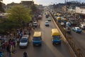 Street scene in the city of Bissau during rush hour with cars in an avenue and people at the Bandim Market, in Guinea-Bissau