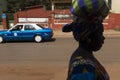 Street scene in the city of Bissau with the silhouette of a woman and a taxi on the background, in Guinea-Bissau.