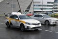 Street scene of city traffic with white Yandex taxi car. Public transport in Moscow