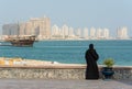 Street scene in Doha, Qatar with lady wearing traditional Qatari black dress and head cover