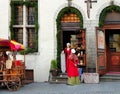 Street scene in old Tallinn, Estonia girl in medieval red dresses selling fried almonds for tourist in an old tradi