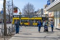 Street scene with pedestrians and a typical Berlin bus turning left at the crossroads of a rural shopping street