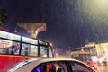 Street scene with public transport in heavy rainfall at night during monsoon in Chennai, India