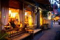 Street scene with restaurant, lights, and people at night seen from Greenwich Village, West Village Manhattan.