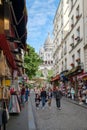 Street scene with souvenir shops in Montmartre with a view of the Sacre Coeur Basilica