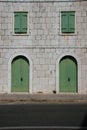 Street scene - stone wall with green doors and windows