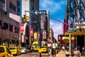 Street scenery at Broadway in Manhattan, NYC. Picture with traffic and cabs and the famous theater, musical ads and billdboards.