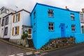 Street in a seaside town, with colorful facades of buildings, en