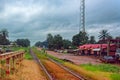 Street sellers peddle their goods around a road and railway at rainy overcast day. Kamsar, Guinea, around a road and rail in