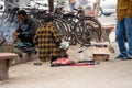 street side cobbler sitting on road and mending shoes in the winter months in sector 17 chandigarh during morning