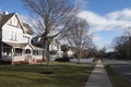 Street and sidewalk of suburban homes with leafless late fall winter season trees Royalty Free Stock Photo