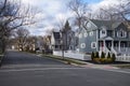 Street and sidewalk of suburban neighborhood homes with leafless late fall winter season trees