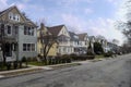 Street and sidewalk of suburban neighborhood homes with leafless late fall winter season trees