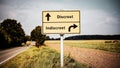 Street Sign Discreet versus Indiscreet Royalty Free Stock Photo