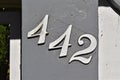 Street sign number 442 on a gray wall