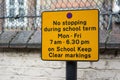 A street sign tells drivers no stopping during term time on keep school clear markings